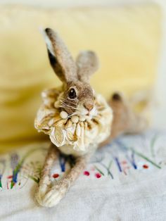 a small stuffed rabbit sitting on top of a bed