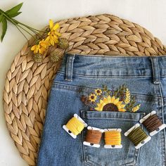 a pair of jeans with sunflowers in the back pocket and some pins attached to them