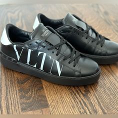 Black Vltn Sneakers By Valentino Garavini. Only Worn To Try On!! Comes With Box, Dust Bag, Extra Laces, And Care Card. Size 37. Fits True To Size. Designer Black Custom Sneakers With Logo Print, Designer Black Low-top Custom Sneakers, Luxury Black Custom Sneakers With Studded Outsoles, Designer Black Sneakers With Logo Print, Luxury Black Low-top Custom Sneakers, Luxury Black Sneakers With Logo, Luxury Black Sneakers With Logo Print, Valentino Shoes Men, Valentino High Top Sneakers