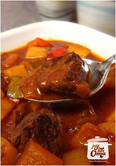 a spoon full of stew with meat and vegetables