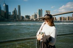 a woman standing on the side of a bridge