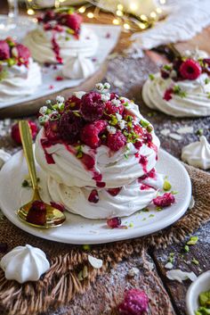 a cake with white frosting and raspberry toppings on a wooden table