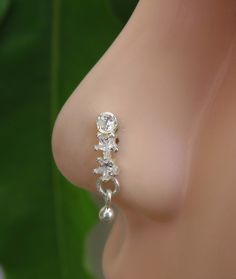 a close up view of the side of a woman's breast with diamond earrings on it