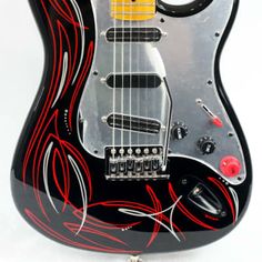 an electric guitar with red and black designs on it