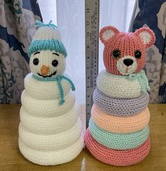 two crocheted teddy bears sitting next to each other on top of a table