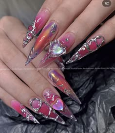 a woman's nails with pink and silver designs on them, including hearts in the middle