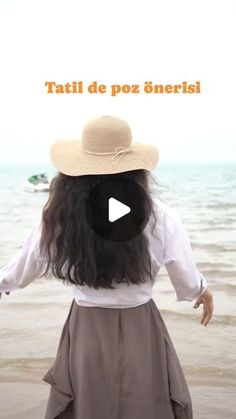 a woman standing on top of a beach next to the ocean with her hands out