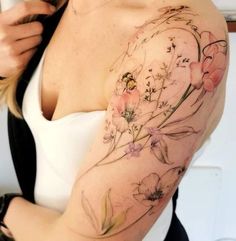 a woman with a flower tattoo on her arm and shoulder is looking at the camera