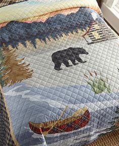 there is a bear and boat quilt on the bed