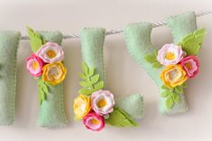 felt flowers are hanging on a clothes line with the letters y, v, and f