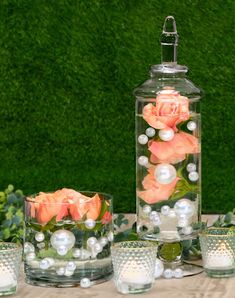 three vases filled with flowers and pearls on top of a table