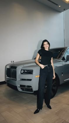 a woman standing next to a silver car