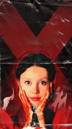 a woman with her hands on her face in front of a red and black background