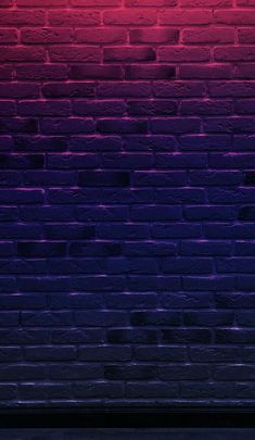 a red and purple brick wall next to a bench