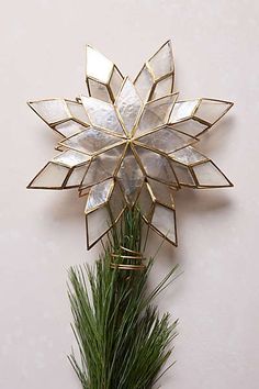 a white and gold christmas ornament hanging on a wall