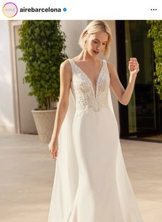 a woman in a white wedding dress is walking down the street with her hand on her hip