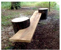 two wooden benches made out of logs in the woods