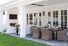 an outdoor dining area with wicker chairs and white tablecloths on the patio