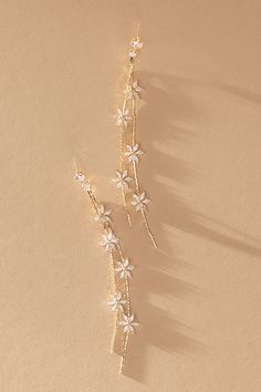 two pairs of gold - plated earrings with white flowers and leaves on the side