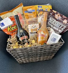 a wicker basket filled with snacks and drinks on top of a blue carpeted floor