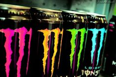 six cans of monster energy drink with neon colors