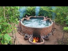 an outdoor hot tub with two people in it and fire coming out from the side