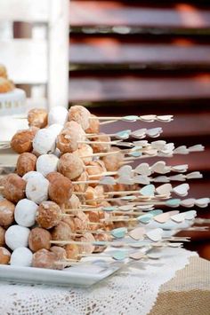 there are many donuts that are on the plate and some skewers in front of them