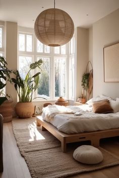 a bed room with a neatly made bed and some potted plants on the floor