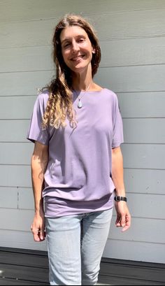 Once you wear the Flow Tee, you'll just want to keep it on! Made with super soft and comfy Brushed Poly (same as the So-Fine waistband fabric) Easy wear and easy care! Washer and dryer friendly. The fit is loose on top with a fitted bottom band. WaistHipsChest X-Small -  W 26-28"   +  H 33-34  +   C 30-33 Small -      W 28-30"  +  H 35-36  +   C 33-36 Medium - W 30-32"  +  H 37-38   +   C 36-39 Large -     W 32-34"   +  H 40-41   +   C 39-42 X-Large -  W 34-36"  +  H 42-43   +   C 42-44 Unsure a Slouchy Short Sleeve Tops For Loungewear, Casual Purple Top For Everyday, Slouchy Tops For Loungewear, Versatile Tops With Relaxed Fit For Everyday, Versatile Relaxed Fit Top For Everyday, Relaxed Fit Versatile Top For Everyday, Slouchy Top For Spring, Casual Solid Slouchy Tops, Casual Slouchy Solid Tops