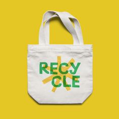 a white tote bag with the words recycle in green and yellow on it