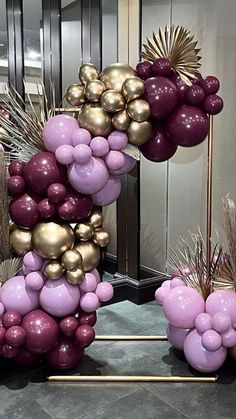 some balloons are arranged in the shape of a letter on top of a stand with plants