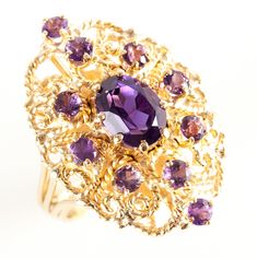 14k Yellow Gold Oval & Round Amethyst Cocktail Ring 2.70ctw Size 7.5 Metal Information: 14k Yellow Gold Total Weight: 12.79g Band Width: 4.7 MM Size: 7.5 Stone Information Main StoneGem Type: Amethyst Shape: Oval (9 x 7mm) Color: Purple Clarity/Quality: A Carat Weight: 1.7ct Number of Stones: 1 Accent StonesGem Type: Amethyst Shape: Round (3.0mm) Color: Purple Clarity/Quality: B Carat Weight: 0.1ct Number of Stones: 10 Total estimated ctw (carat total weight): 2.7ctw Estimated Retail Price: Oval Purple Amethyst Ring With 17 Jewels, Amethyst Cocktail Ring, Jewellery Showroom, Jewelry Website, Spring Jewelry, Spring Design, Custom Jewelry Design, Cocktail Ring, Cocktail Rings