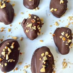 chocolate covered candies with nuts scattered around them