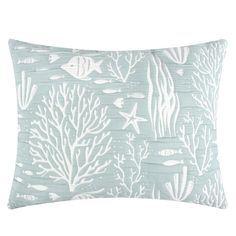 a blue pillow with white corals and fish on the front, along with an ocean theme