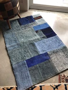 a patchwork rug on the floor in front of a door