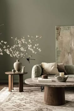 a living room filled with furniture and flowers in vases on top of a table