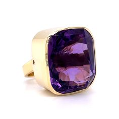 Bezel Set Amethyst Cocktail Ring in 14k Yellow Gold. From the Ancient Egyptians to the Middle Ages and beyond, amethysts have been a highly sought after gemstone with a vast history of international folklore and symbolism. This one of a kind cocktail ring features a 35.41 carat cushion cut purple amethyst finished in 14K yellow gold. The amethyst has a vibrant, dark violet hue. The center stone is bezel set on polished yellow gold band. What a better way to celebrate one of Minneapolis’ favorite Luxury Purple Ring With Bezel Setting, Formal Large Stone Amethyst Jewelry, Formal Amethyst Rings With Large Stone, Formal Amethyst Jewelry With Large Stone, Formal Amethyst Ring With Large Stone, Luxury Yellow Gold Amethyst Ring With Bezel Setting, Formal Amethyst Rings With Bezel Setting, Classic Formal Amethyst Ring With Large Stone, Classic Large Stone Amethyst Ring For Formal Events