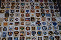 many different police patches are on the table top, and there is no image here to provide a caption for