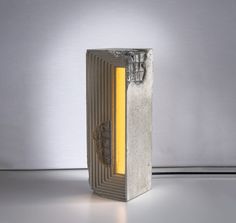 a concrete sculpture with a yellow light coming out of it