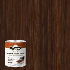 a can of brown wood stain sitting on top of a wooden floor next to a wall