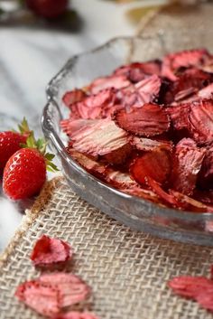 some strawberries in a glass bowl on a table