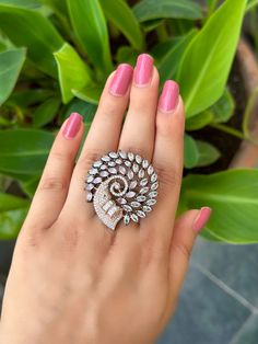 a woman's hand holding a ring with diamonds on it