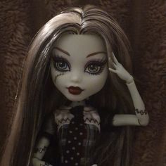 a close up of a doll with long hair and makeup on it's face