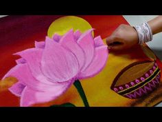 a woman is painting a flower with acrylic paint on a large piece of paper