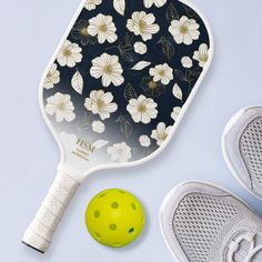 a tennis racquet, ball and shoe on a blue background with white flowers