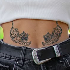 a woman's stomach with tattoos on it and two tigers in the back pocket