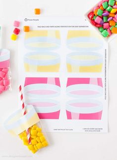 candy and candies are on the table next to a paper cup that is shaped like an ice cream cone