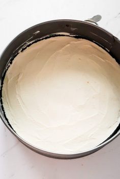 a pan filled with white frosting sitting on top of a counter