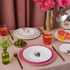 the table is set with plates, silverware, and grapefruits in front of a disco ball