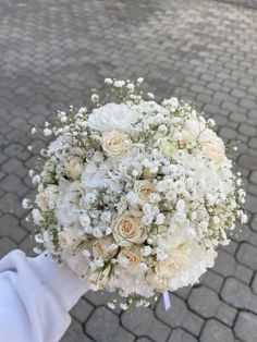 a bridal bouquet is being held on the street